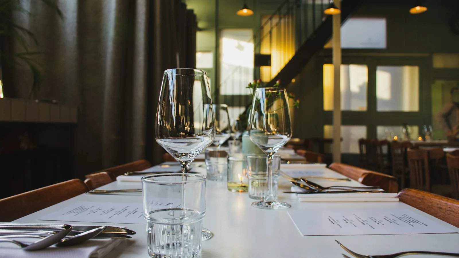Wijnkaart en glazen op een gedekte restauranttafel